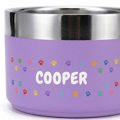 Detail of the printed pattern band on a lilac Personalised Pattern Dog Bowl, showing crisp multicoloured paw prints around the name COOPER