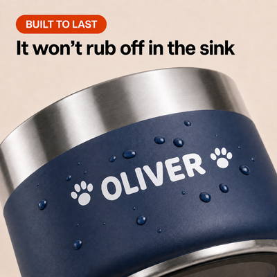 Water beading on the printed name of a navy Personalised Nameplate Dog Bowl, showing the print sits flush with no edge to lift