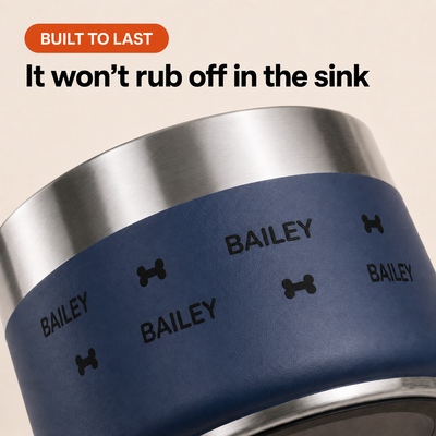 Water beading on a navy Personalised Wraparound Dog Bowl printed with the repeating name BAILEY, showing the print does not rub off